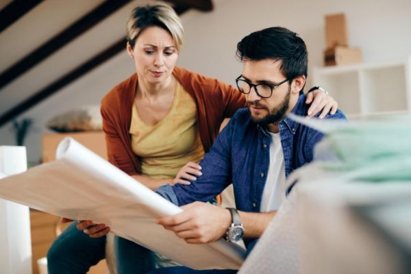 que hacer antes de un sismo Pareja revisando los planos de su casa para verificar las zonas seguras en un sismo