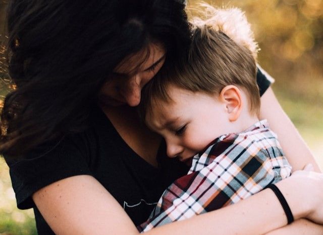 Niño abrazado por su madre con expresión triste, reflejando el impacto emocional del Síndrome de Alienación Parental tras una separación conflictiva.