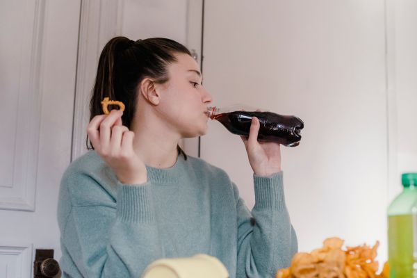 mujer comiendo irritantes tomando refresco mujer comiendo irritantes tomando refresco que causan hipo en algunas personas