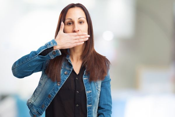 mujer con hipo Mujer cubriendo su boca mientras tiene hipo, mostrando molestia y sorpresa por espasmos del diafragma