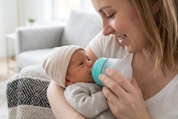 Mamá alimentando a su bebé prematuro con un biberón adecuado