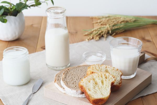 Mesa servida con leche y rebanadas de pan que pueden ser alergenos y no recomendados para algunas mujeres en la lactancia
