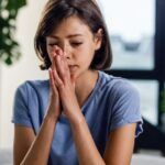 Mujer joven con expresión de angustia y manos juntas en el rostro, reflejando ansiedad por recuerdos traumáticos de infancia