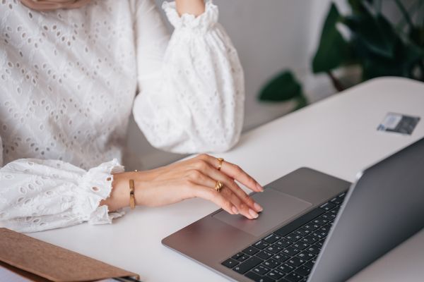 Mujer escribiendo en su computadora sus logros profesionales en su cv para un trabajo remoto