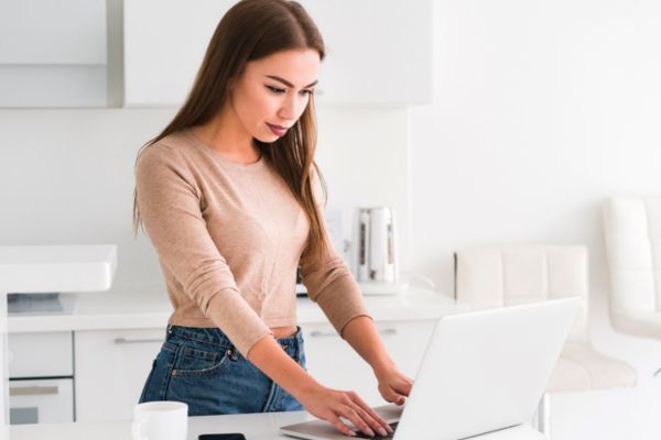 Mujer joven redactando su CV para un trabajo remoto destacando sus habilidades. 