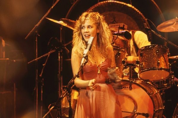Retrato de Stevie Nicks con su mítica imagen mística y rockera, cantando con intensidad y misterio.