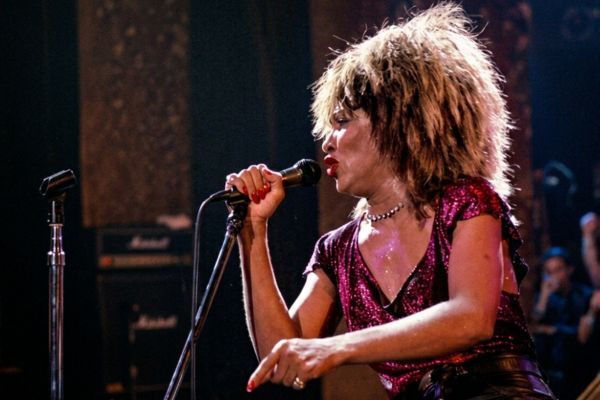 Tina Turner, la reina del rock, canta con pasión y energía. Su voz potente y su mirada decidida transmiten su fuerza.
