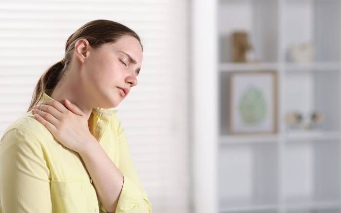Gemini dijo Madre estresada tocándose el cuello con dolor, ilustrando la tensión física y el agotamiento crónicos.