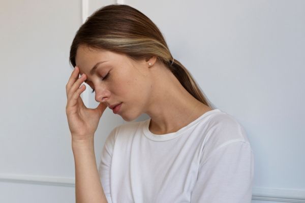 contras pastilla del dia despues Mujer mostrando malestar como dolor de cabeza, posibles efectos de la pastilla del dia después