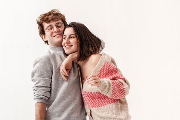 Pareja de adolescentes abrazados y sonriendo mientras viven una relación sana y afectiva durante la adolescencia.