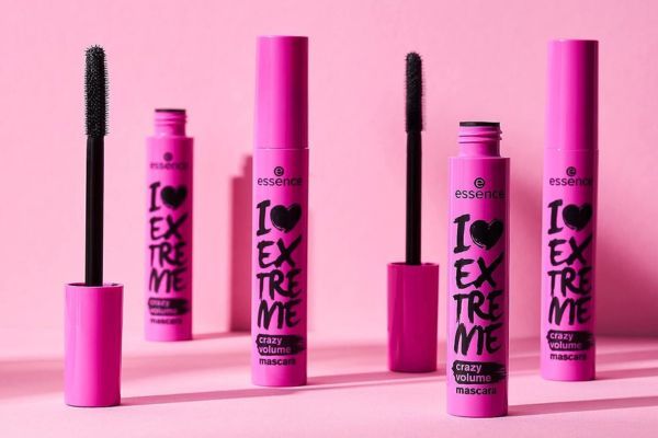 Envases de la máscara para pestañas Essence I Love Extreme Crazy Volume sobre fondo rosa
