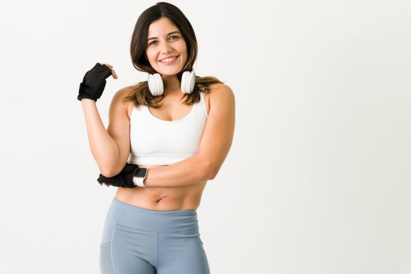Mujer con ropa deportista y actitud positiva, como muestra de su constancia en su rutina de ejercicios.