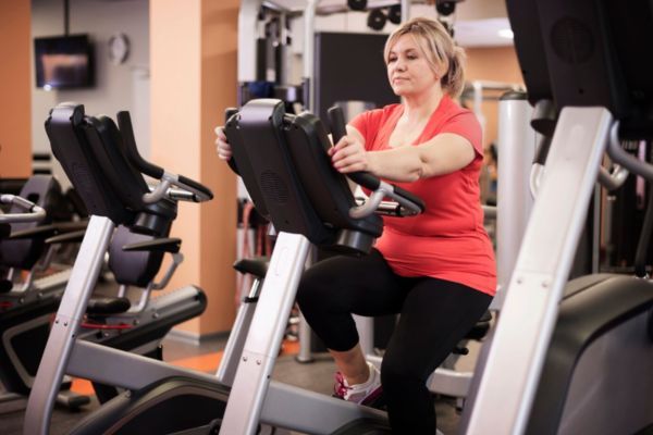 sudar no significa quemar grasa Mujer entrenando en gimnasio, enfocada en técnica más que en la cantidad de sudor.