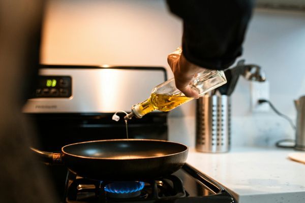 Toma cerrada de una persona usando el mejor aceite para cocinar de acuerdo a sus características