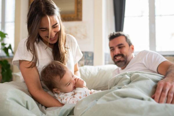 Pareja cuidando en equipo a su bebé al despertar