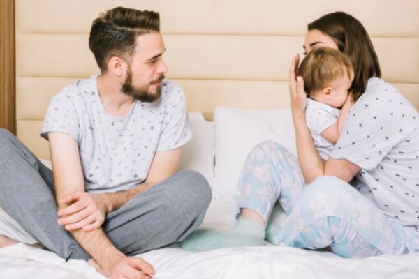 Mamá y papá hablando sobre los cuidados nocturnos del bebé 