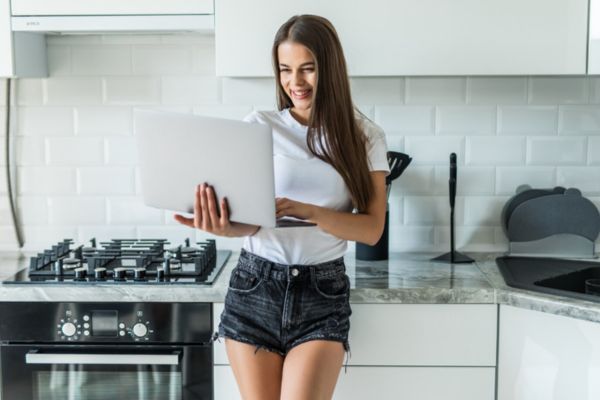 tipos de cocinas a gas Mujer joven en una cocina que muestra una estufa completa